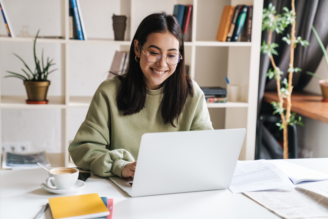 Female student sitting and typing on a laptop