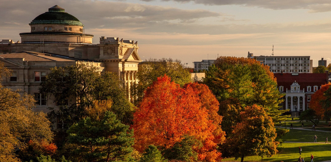 view of campus from up high during the fall showing multiple buildings and orange/red trees