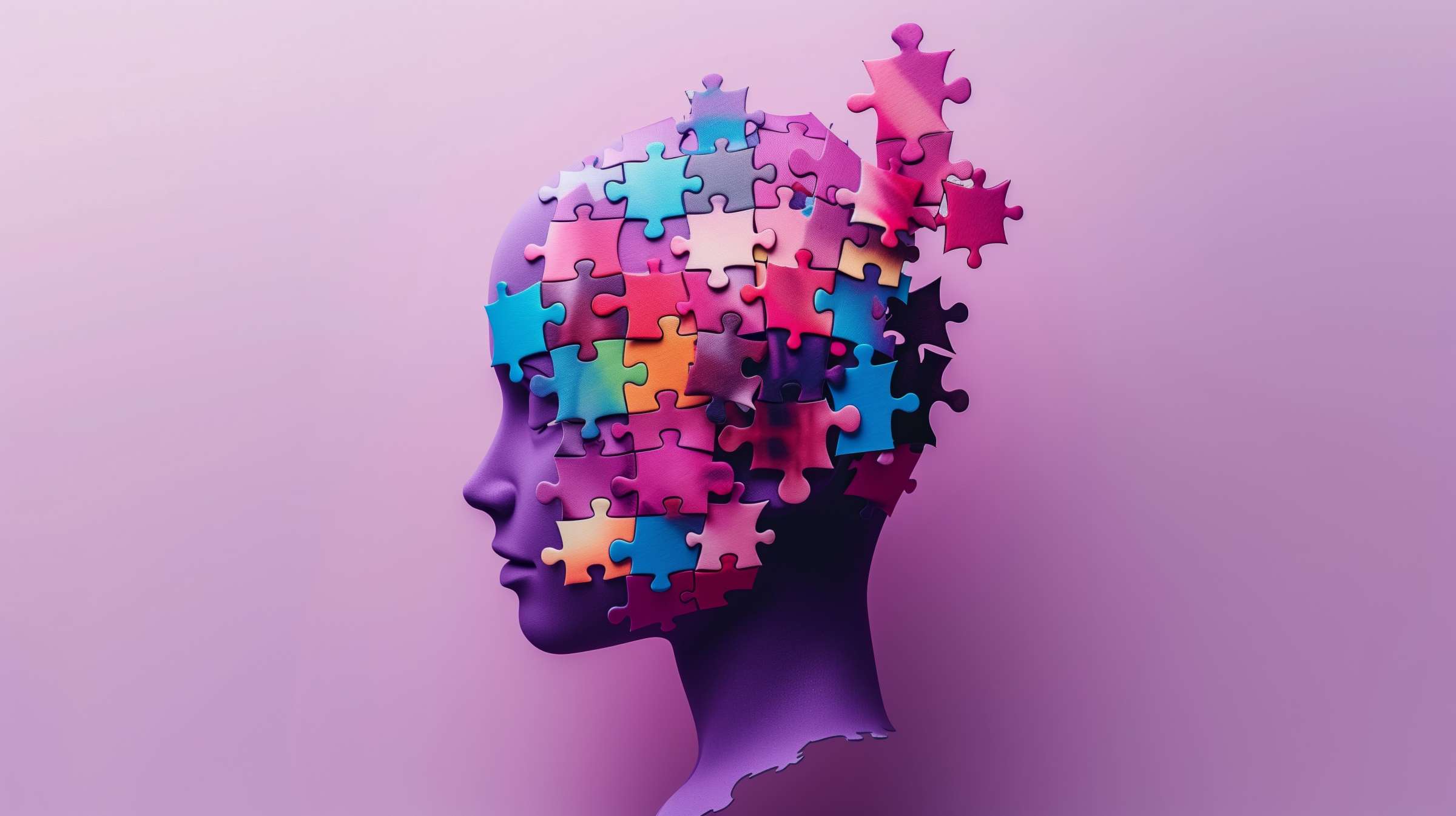 Photo of the side profile of a purple mannequin like structure with puzzle pieces wrapping around the skull of all colors, some floating off of the head of the mannequin