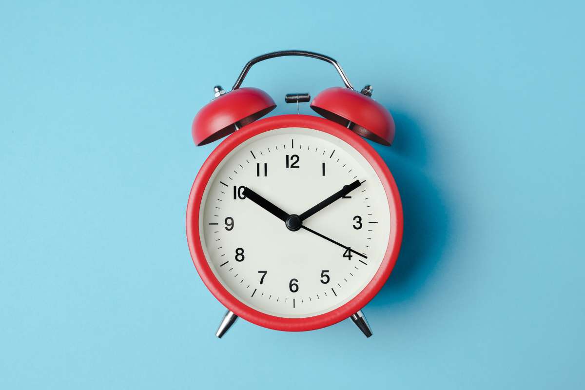 Image of a red analog clock on a blue background