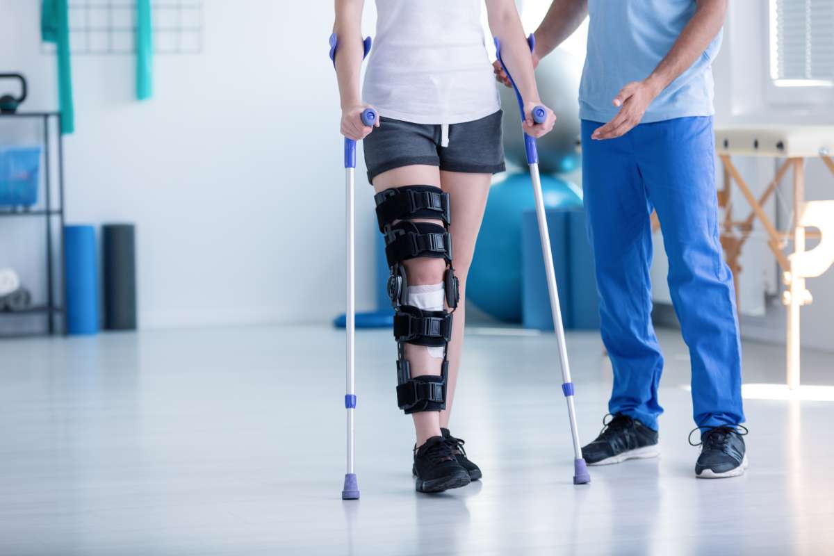 Patient with brace on right leg using crutches