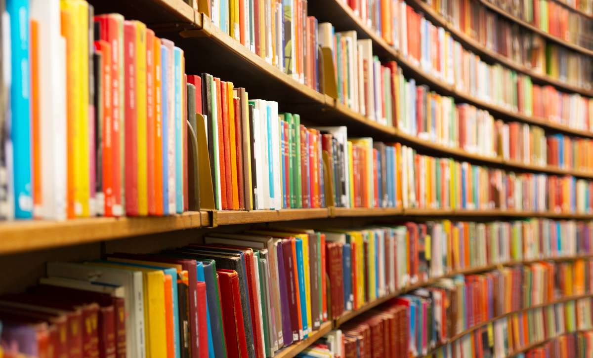 Photo looking down a row of library shelves filled with all kinds of books