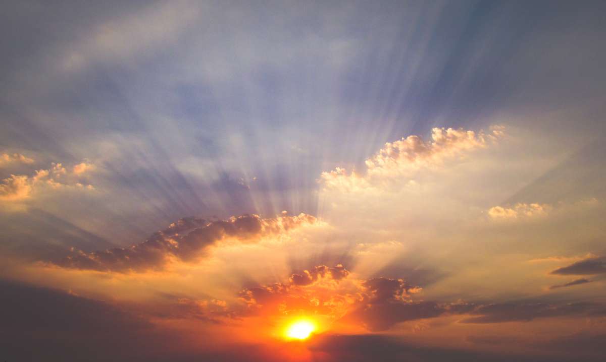 Photo of a sunrise, orange and red with a dark blue sky and clouds