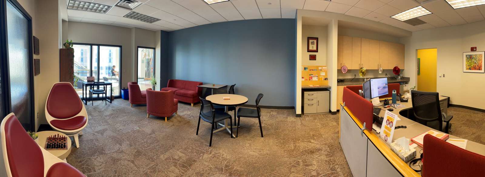 A panoramic photograph of the SAS reception area. Featuring a view of various seating to the left of the entrance, with the reception desk on the right.